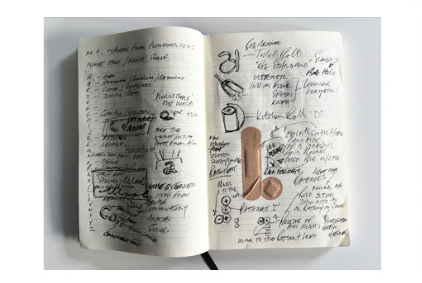 A sketchbook open at a double-page spread filled with notes, designs and sketches in pen.