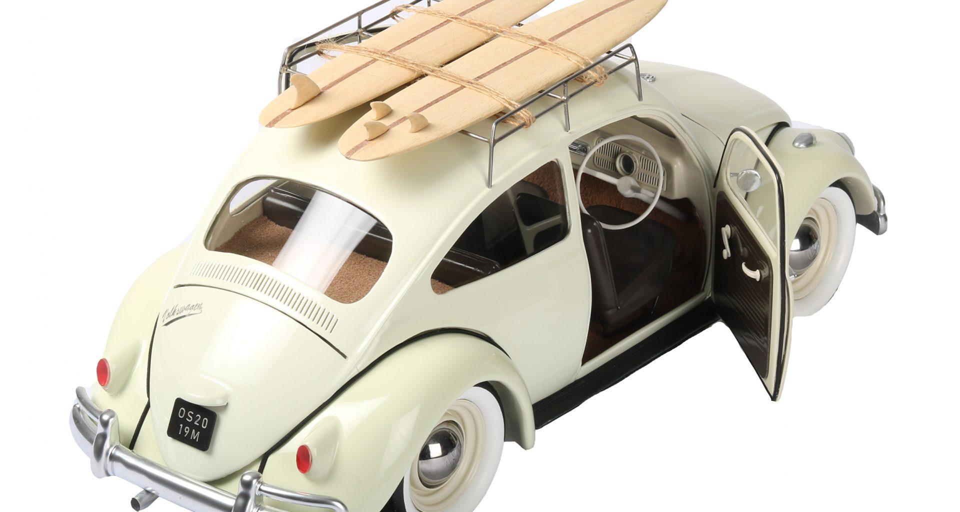 Model of a Volkswagen Beetle with the driver side door open and a pair of surfboards on the roof rack.