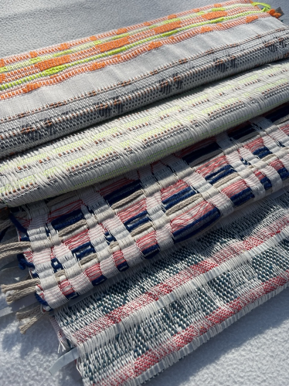 Collection of pale-coloured, patterned fabrics.