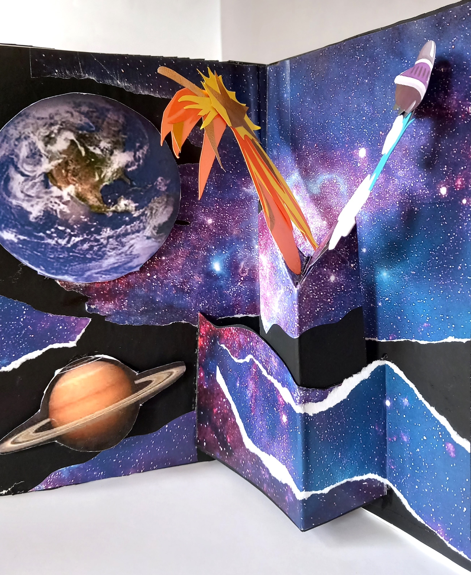 Room corner with space-themed wall mural featuring Earth, Saturn, white rocket, and orange comet against purple-blue starry background