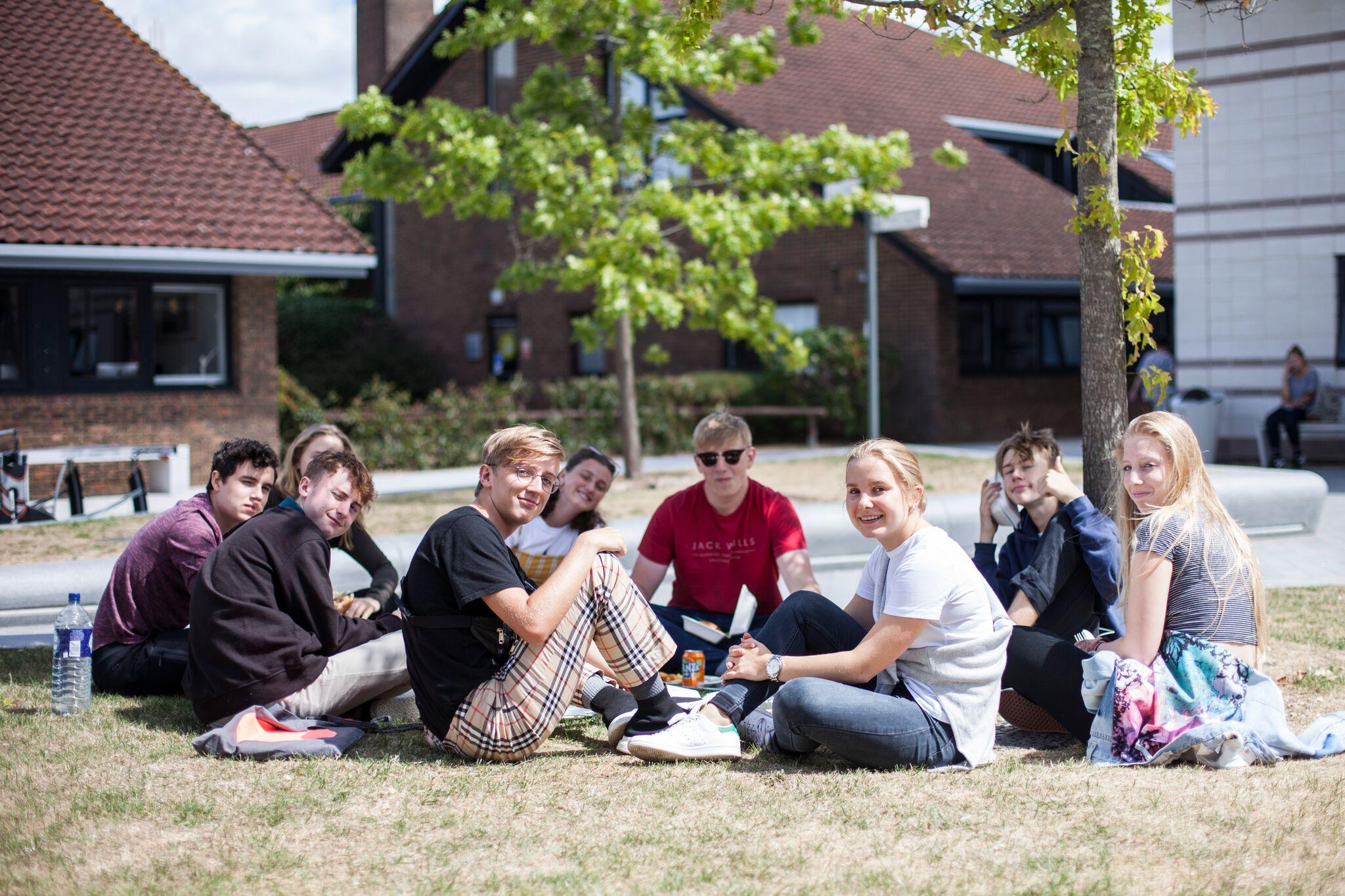 Students gathered into a social group conversing on university campus