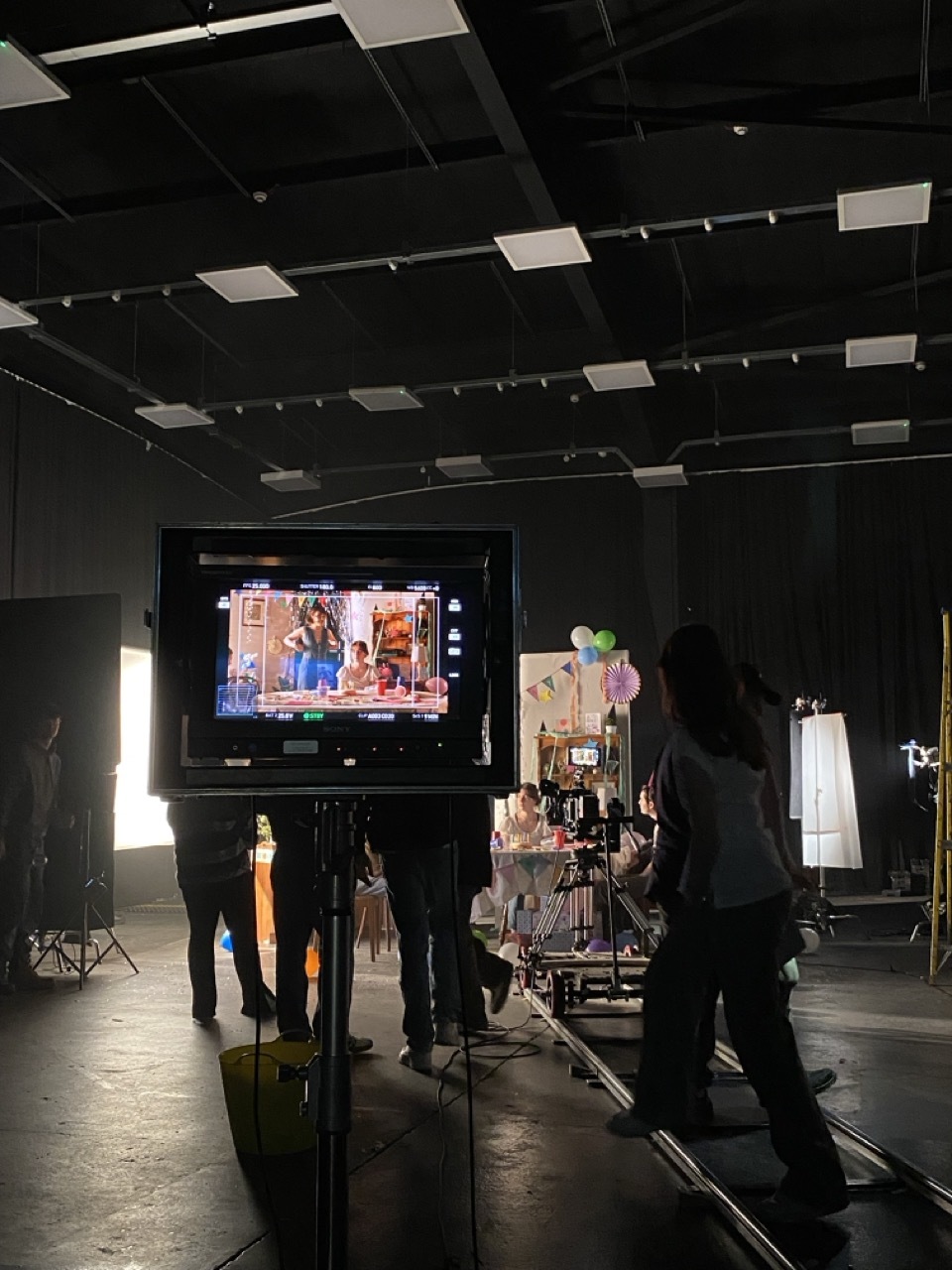 Film equipment in an indoor studio set and crew.