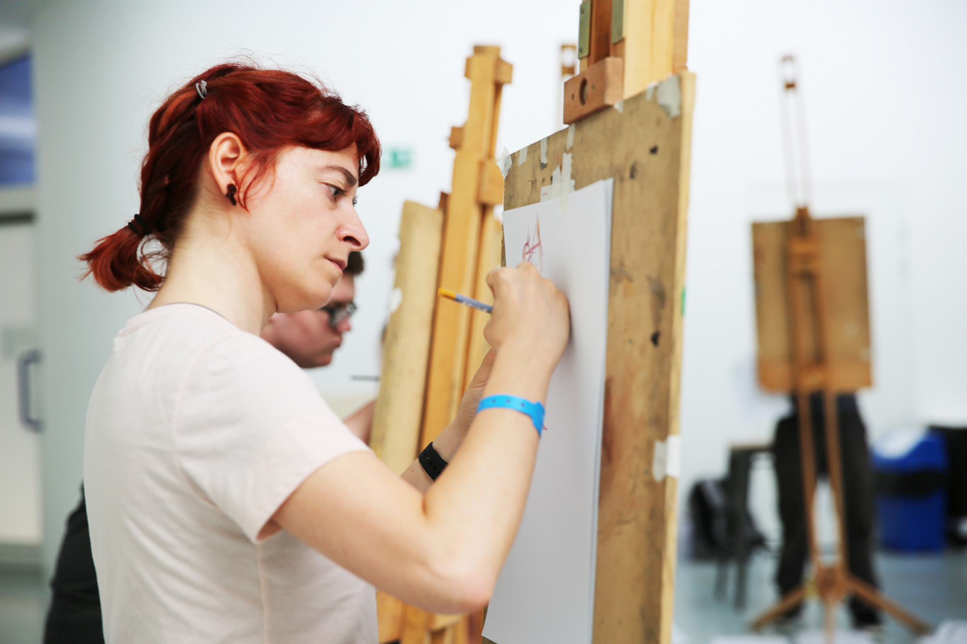 Student drawing on easel