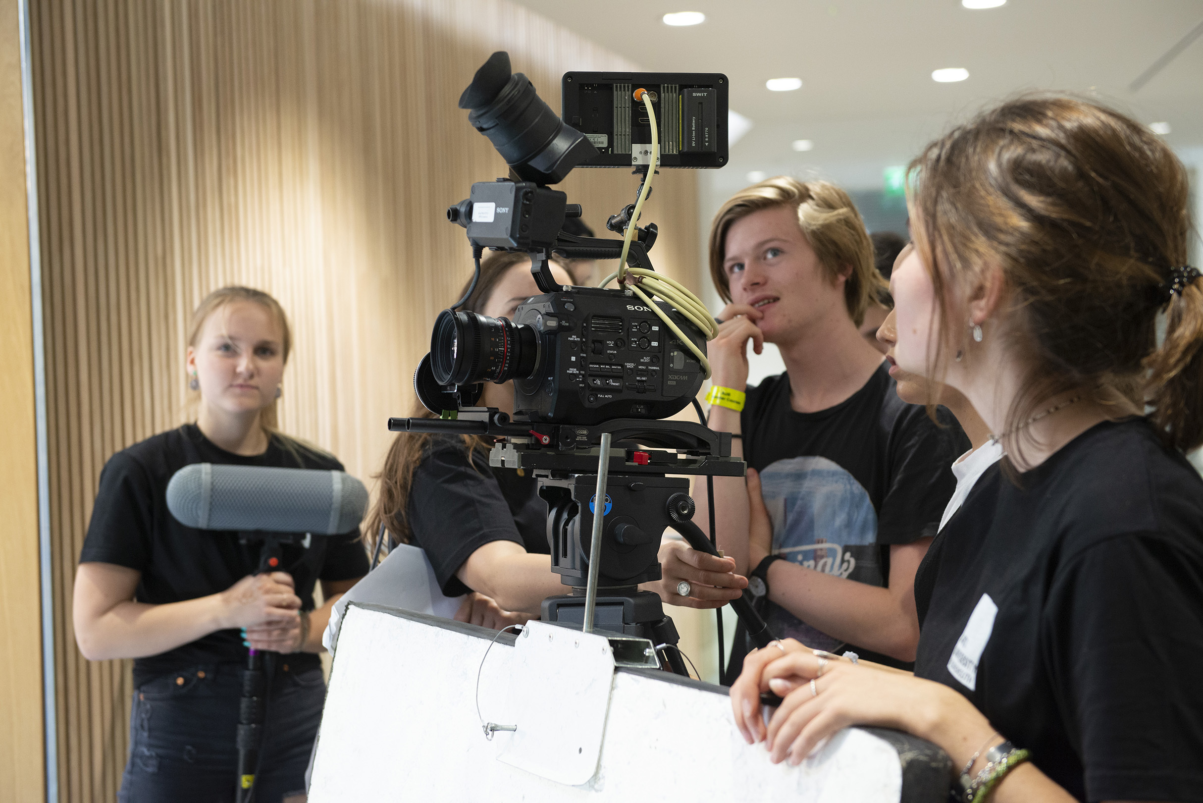 Young students using camera equipment to make a film