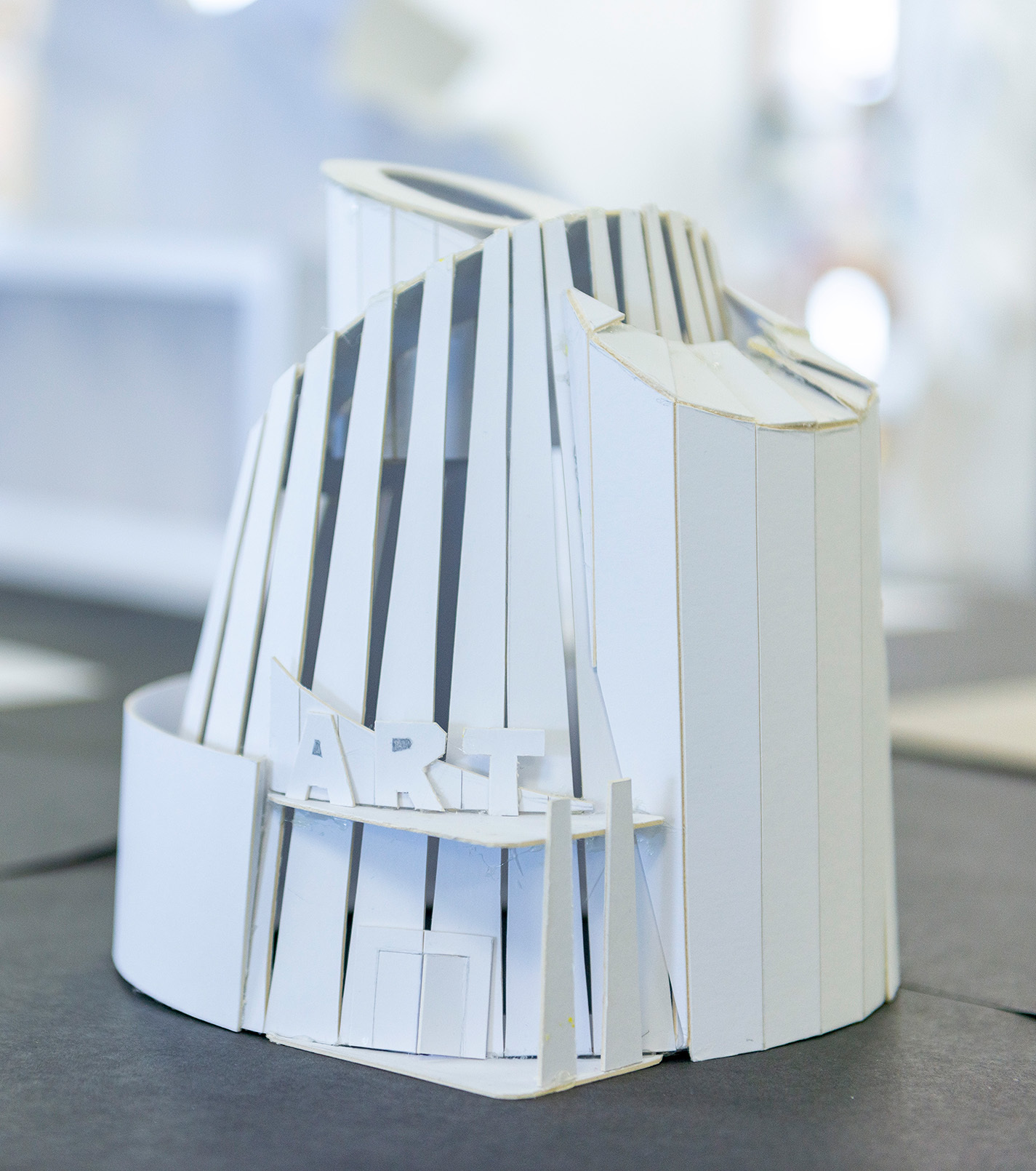An architectural model made out of cardboard pieces. The word "ART" appears over the entrance.