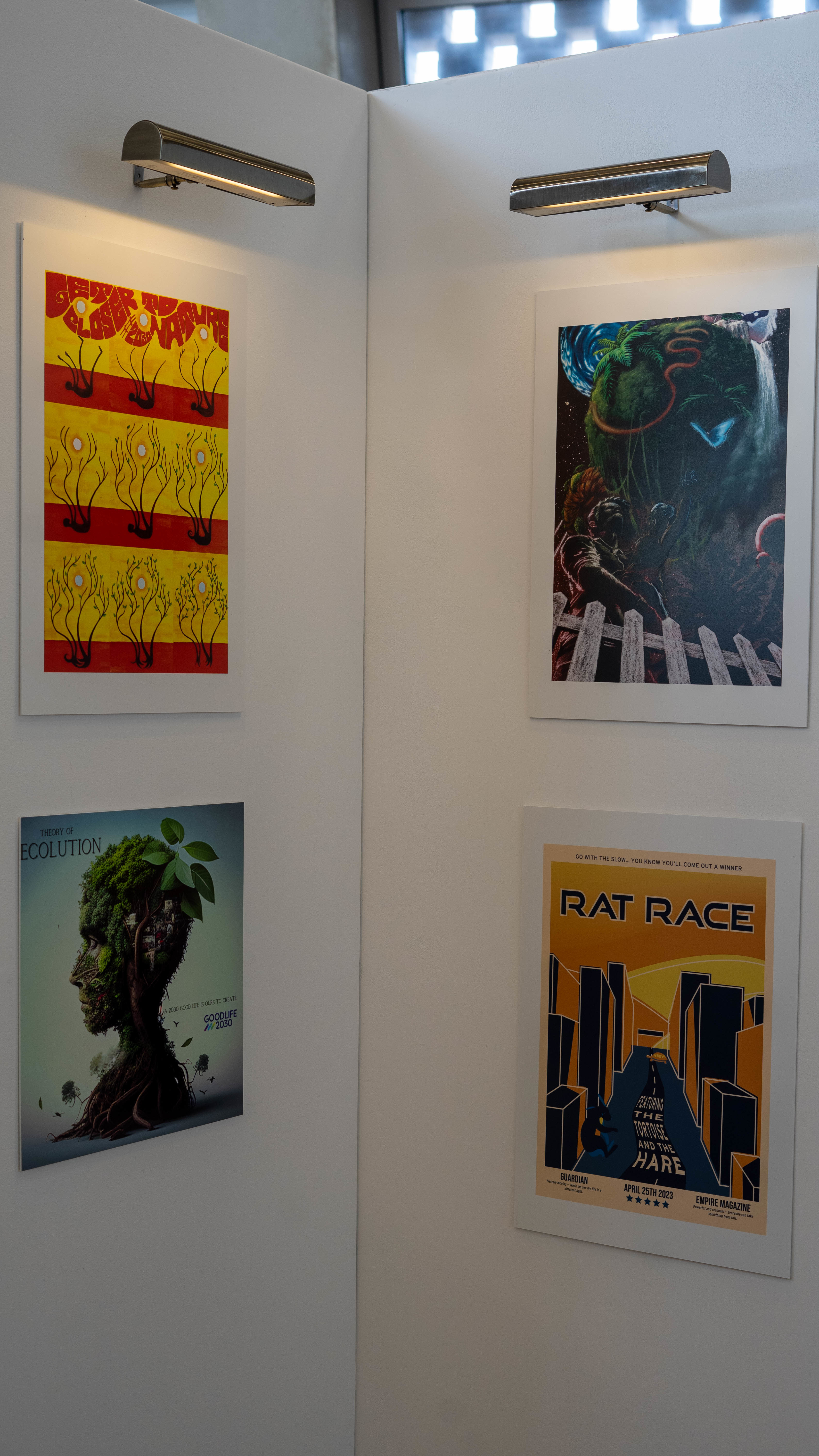 A series of four posters displayed on a gallery corner wall.