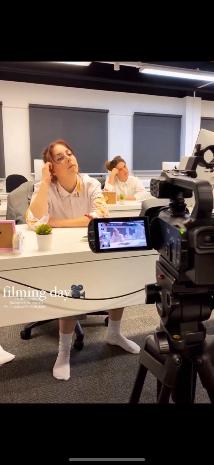 Two AUB students being filmed for a scene set in an office. A camera is visible in the foreground.