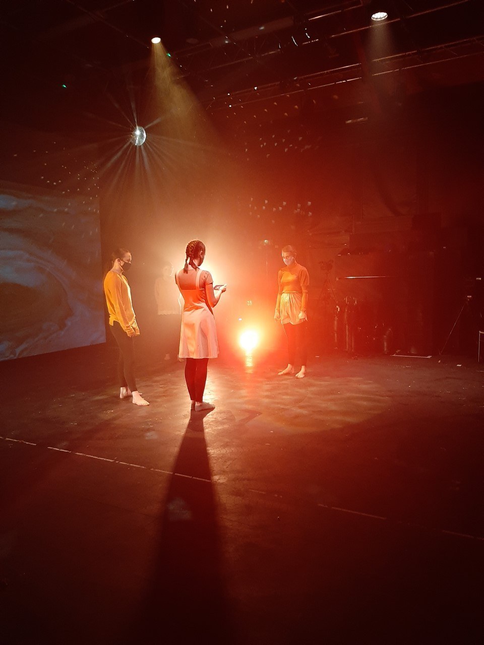 Three BA (Hons) Dance students standing on stage in face masks.