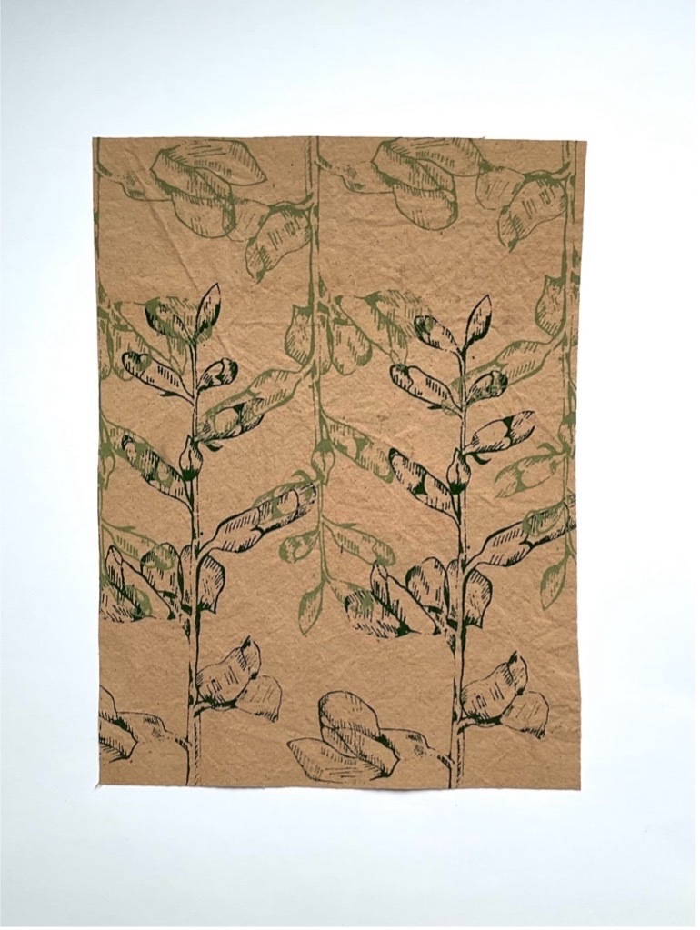 Green florals printed onto brown card.