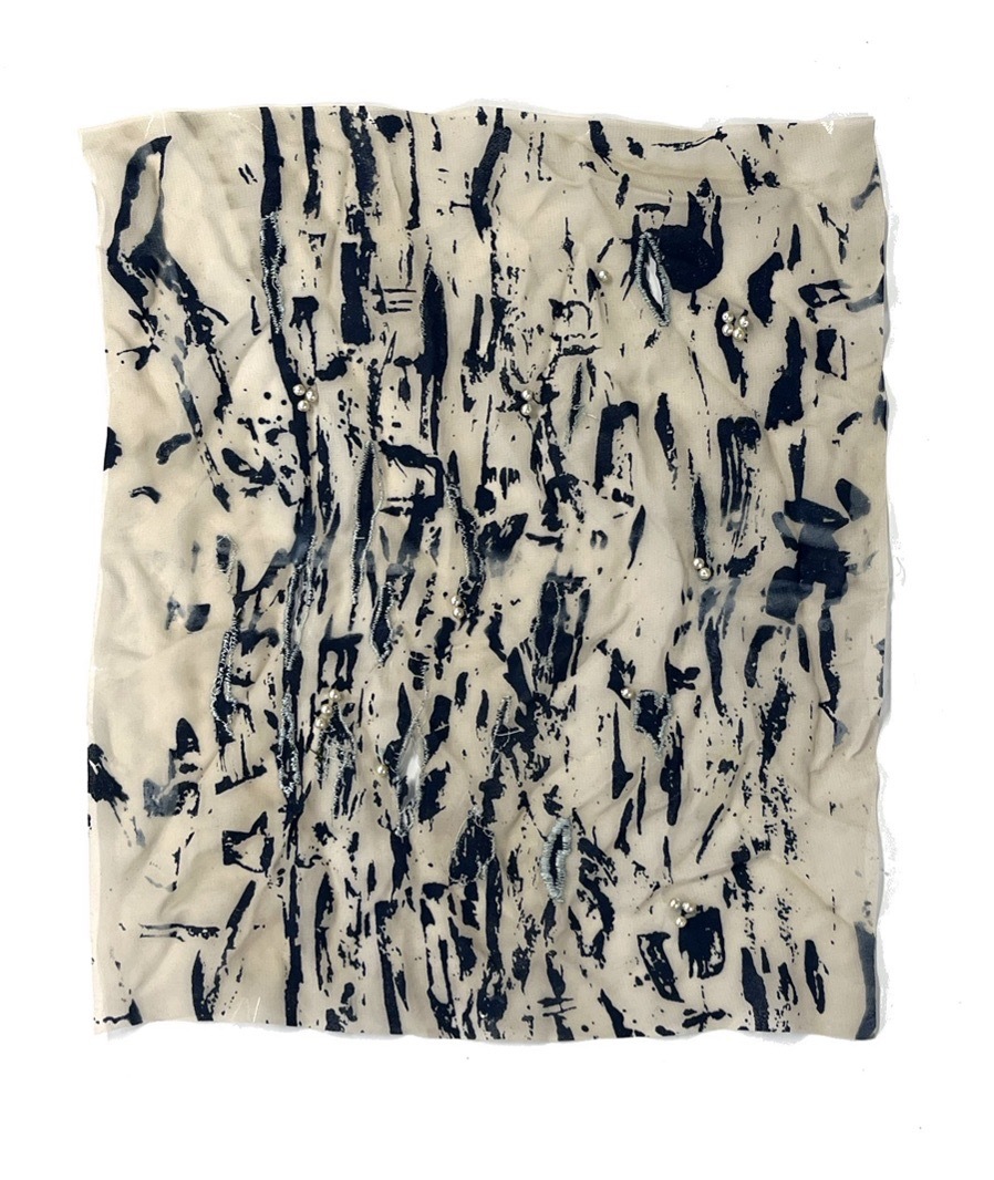 Abstract textile work with dark patterning on an off-white material.