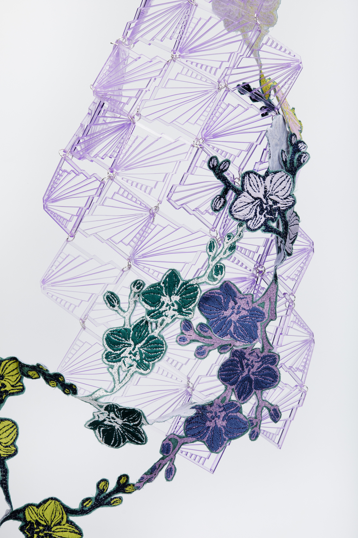 Green and purple layered textile patterning, white background.