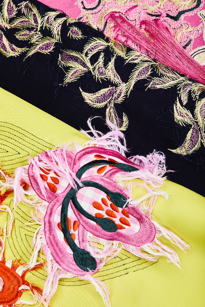 Colourful pink, green and black floral textile patterning.