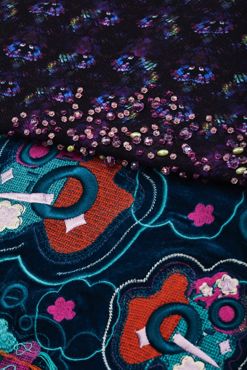 Patterned textiles with embroidered sequins, red, teal and purple.