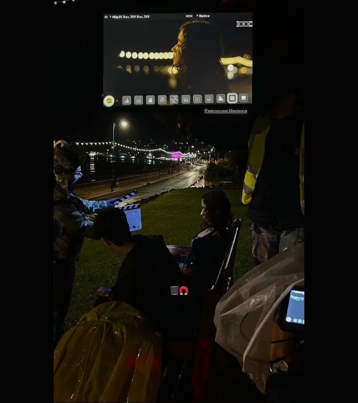 Behind the scenes shot showing camera crew by the side of the road.