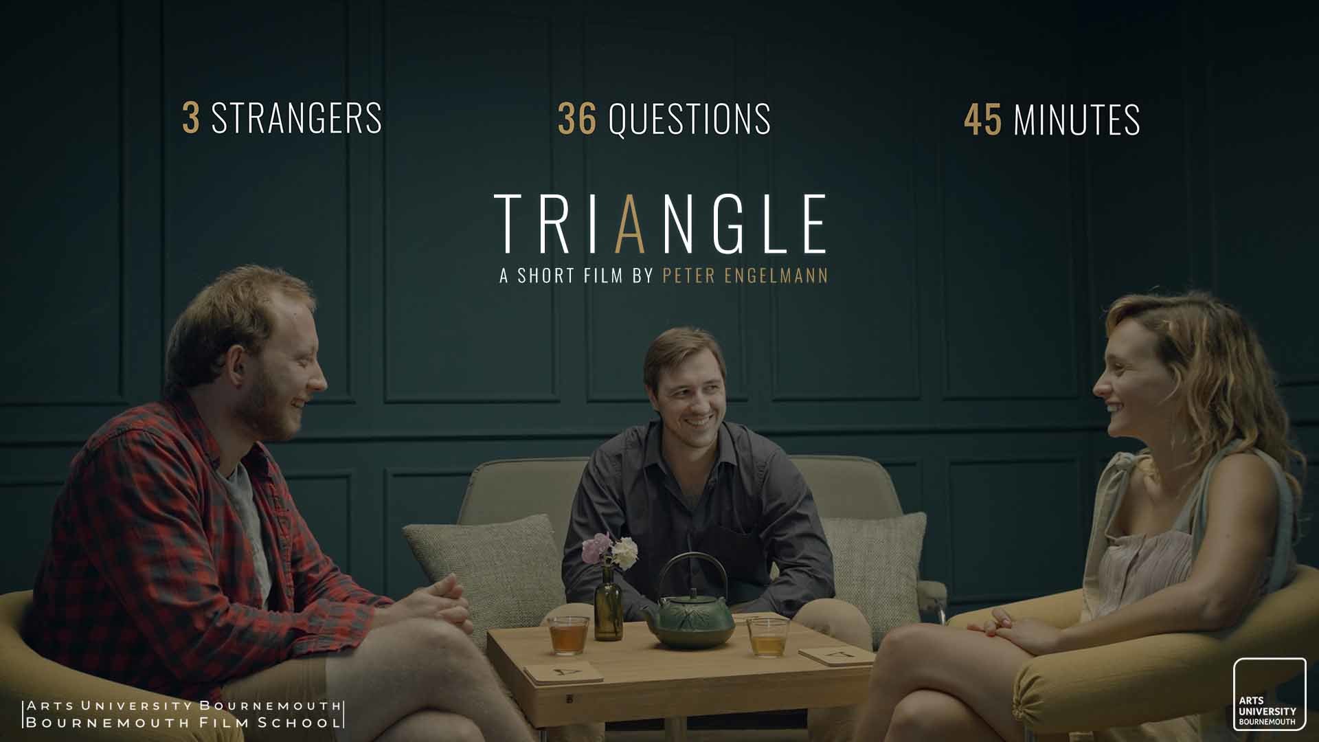 Three seated actors look at each other and smile