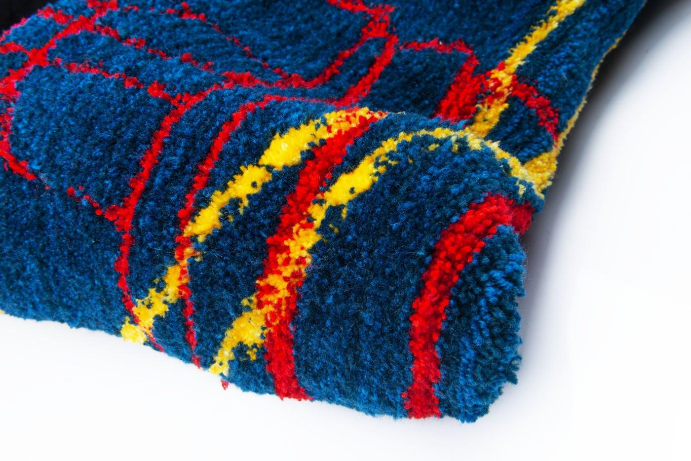 A roll of colourful tufted fabric.