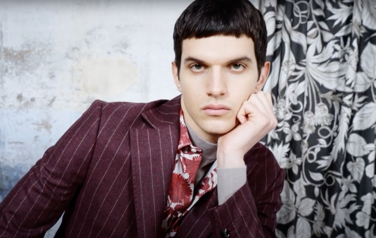 Male model in a burgundy floral and stiped suit.