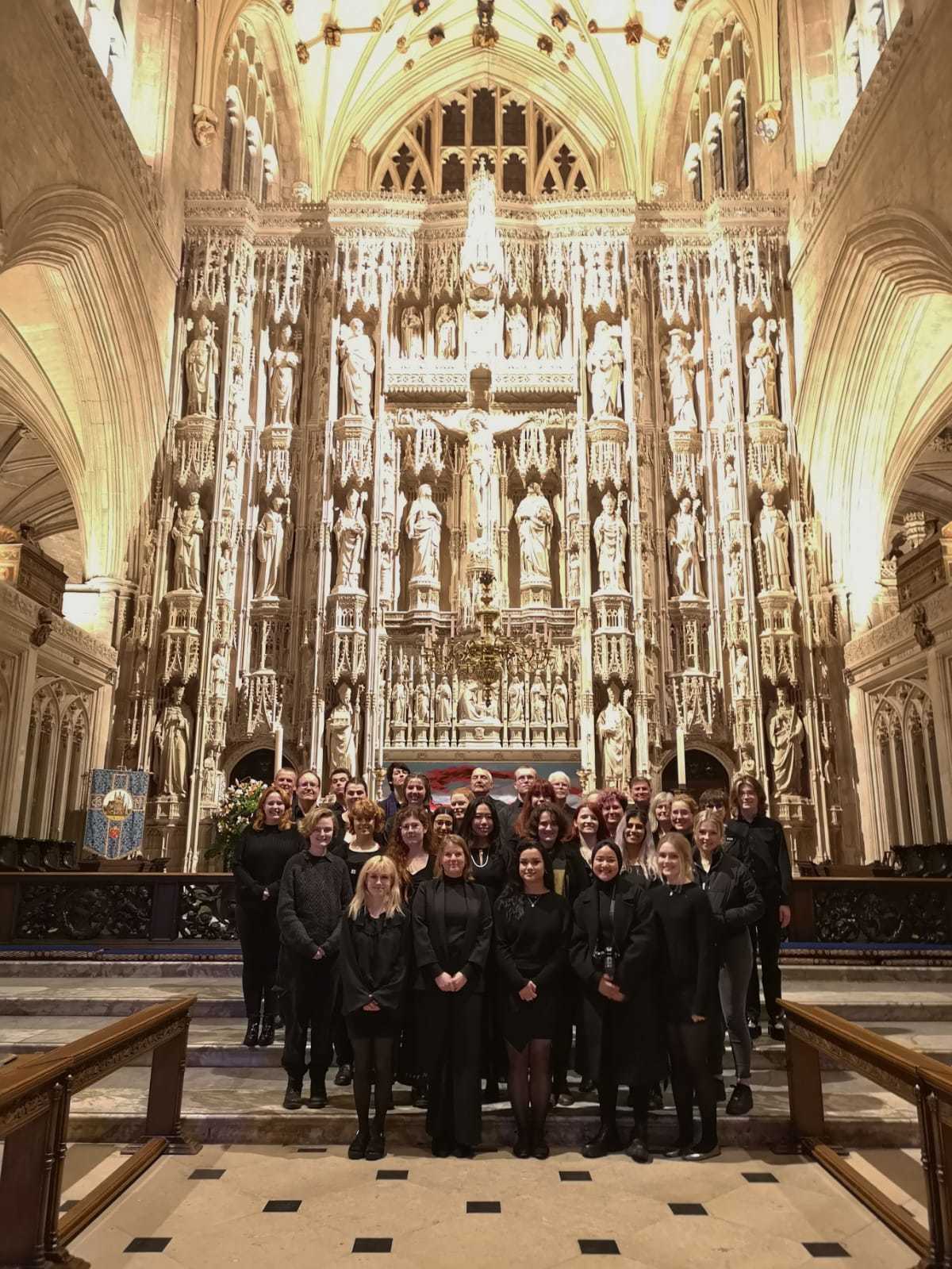 University Music Choir in Winchester cathedral posing for a group photo