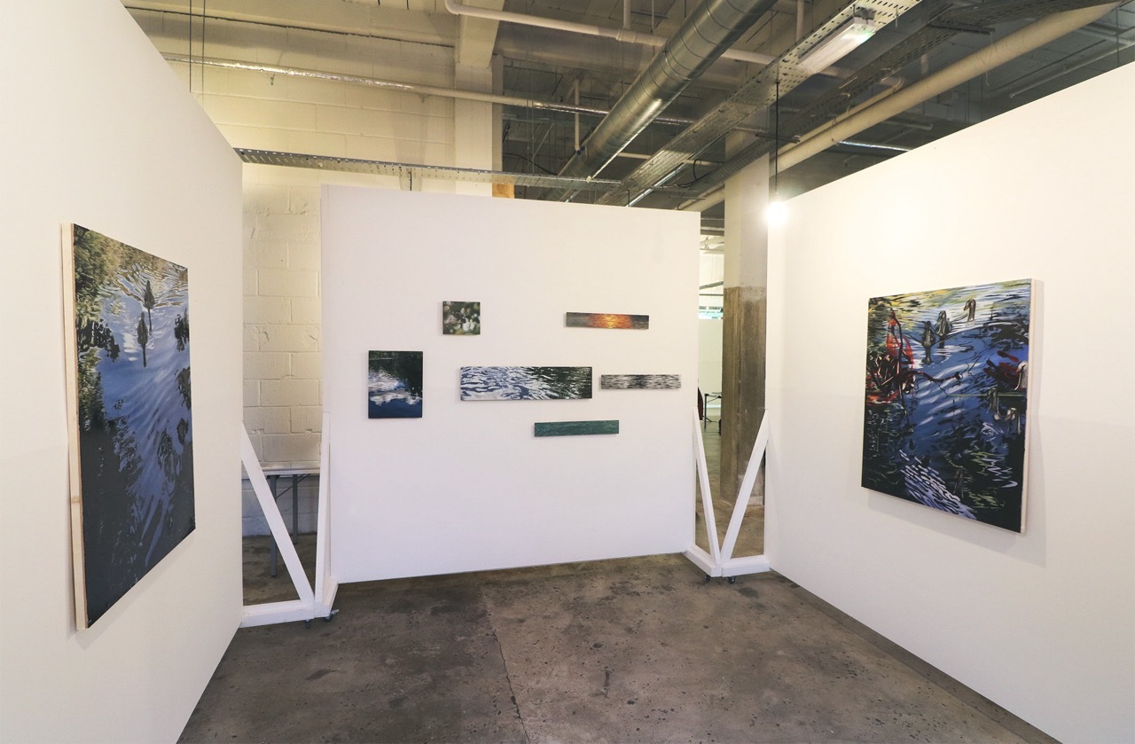 Multiple river paintings in an exhibition.