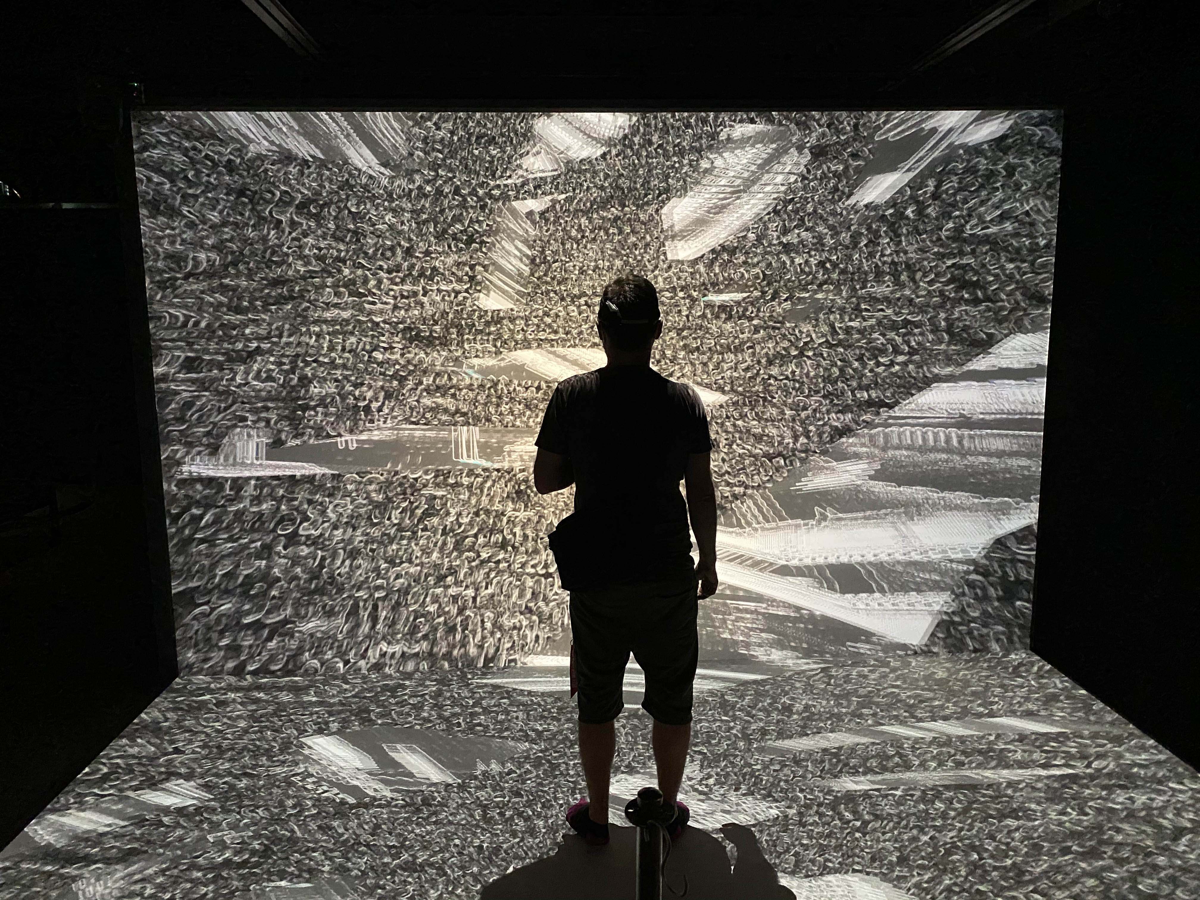 Silhouette of a person standing in front of projected lighting