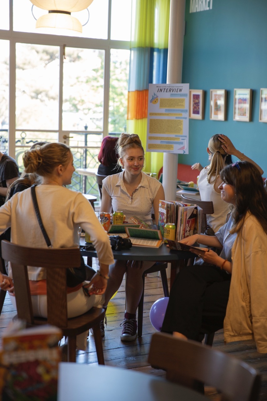 People talking around a table at the Seegull launch event with drinks and copies of the book.