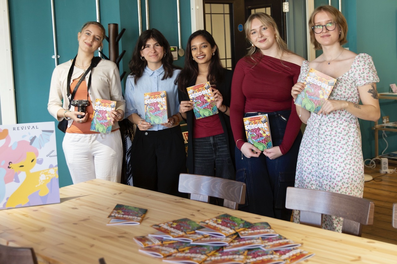 The student team behind Seegull posing with posters and copies with illustrations of the front cover. Maria Bishop is stood on the far right.