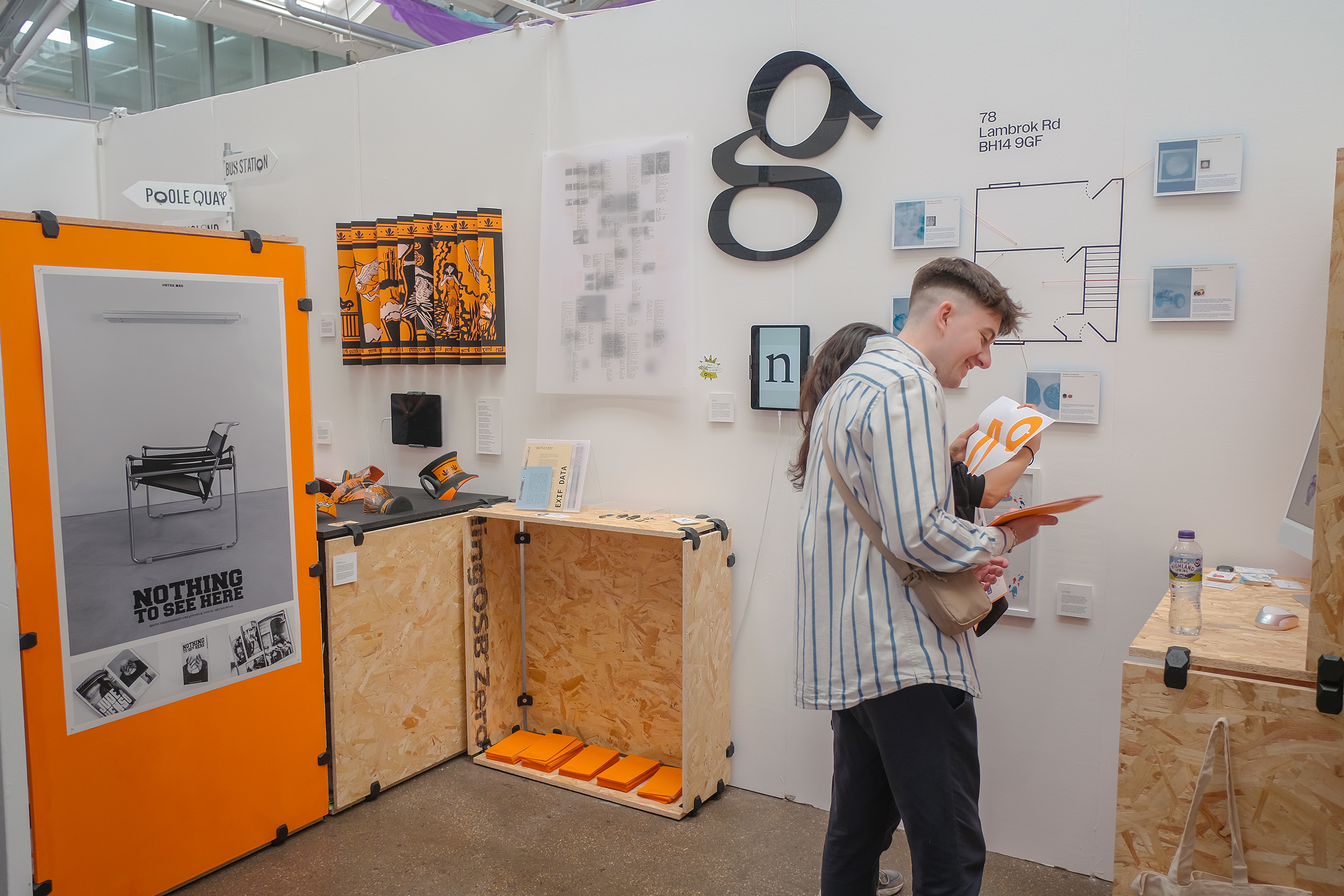 The Visual Communication stand at the London summer show (D&AD New Blood Exhibition) in June 2023 – there's a person standing in the stand looking at the art work on display
