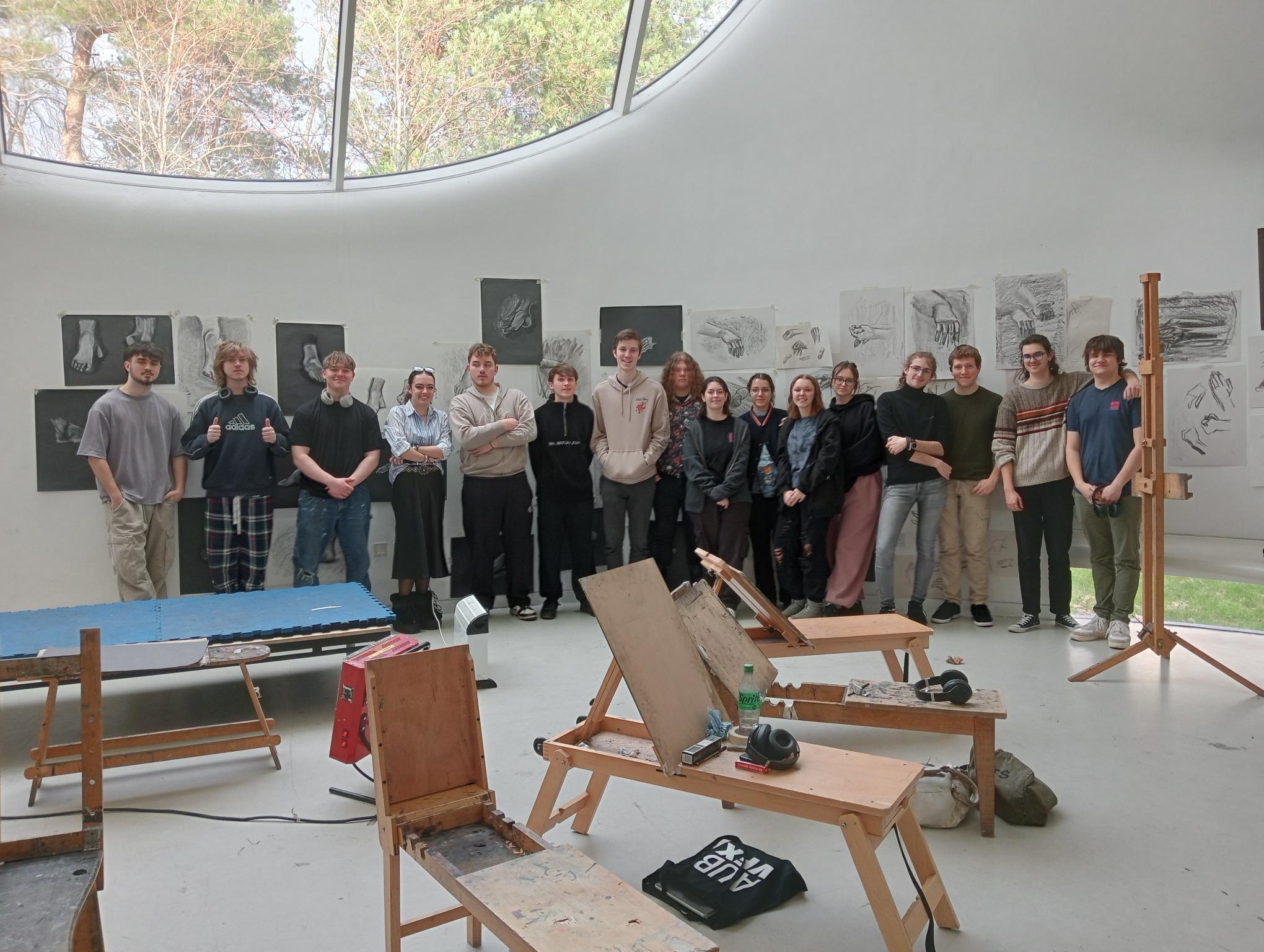 A long line of students stood in the AUB Drawing Studio with easels and artwork displayed around them.
