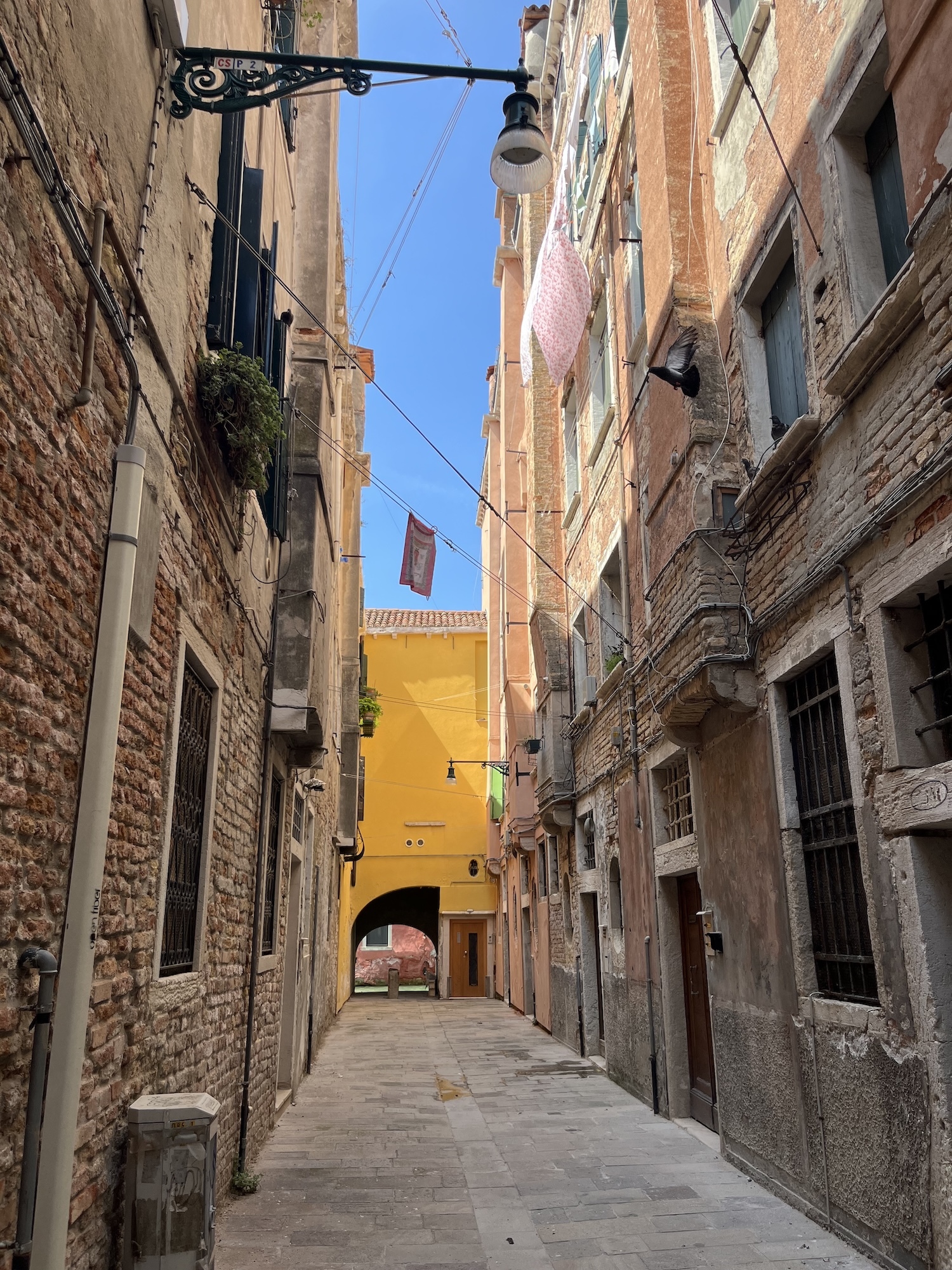 A narrow street in Venice with buildings lining either side.