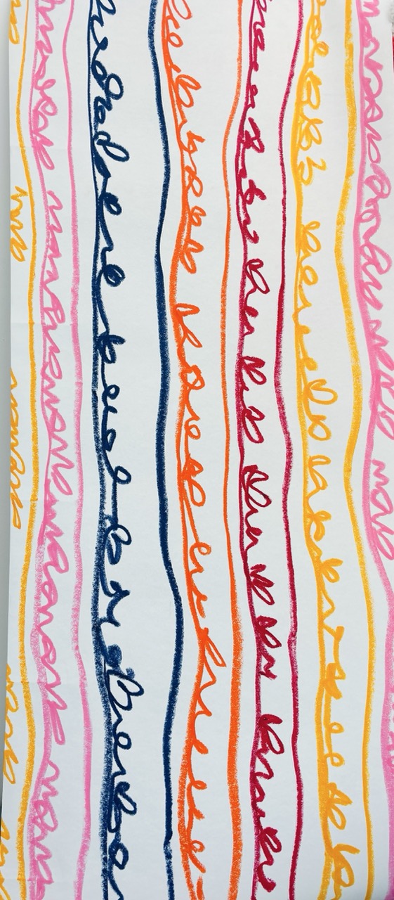 A vertical pattern featuring wavy lines in various colours including pink, orange, red, yellow, and blue, over a white background. The lines have a hand-drawn appearance and run parallel to each other, creating a vibrant and playful design.