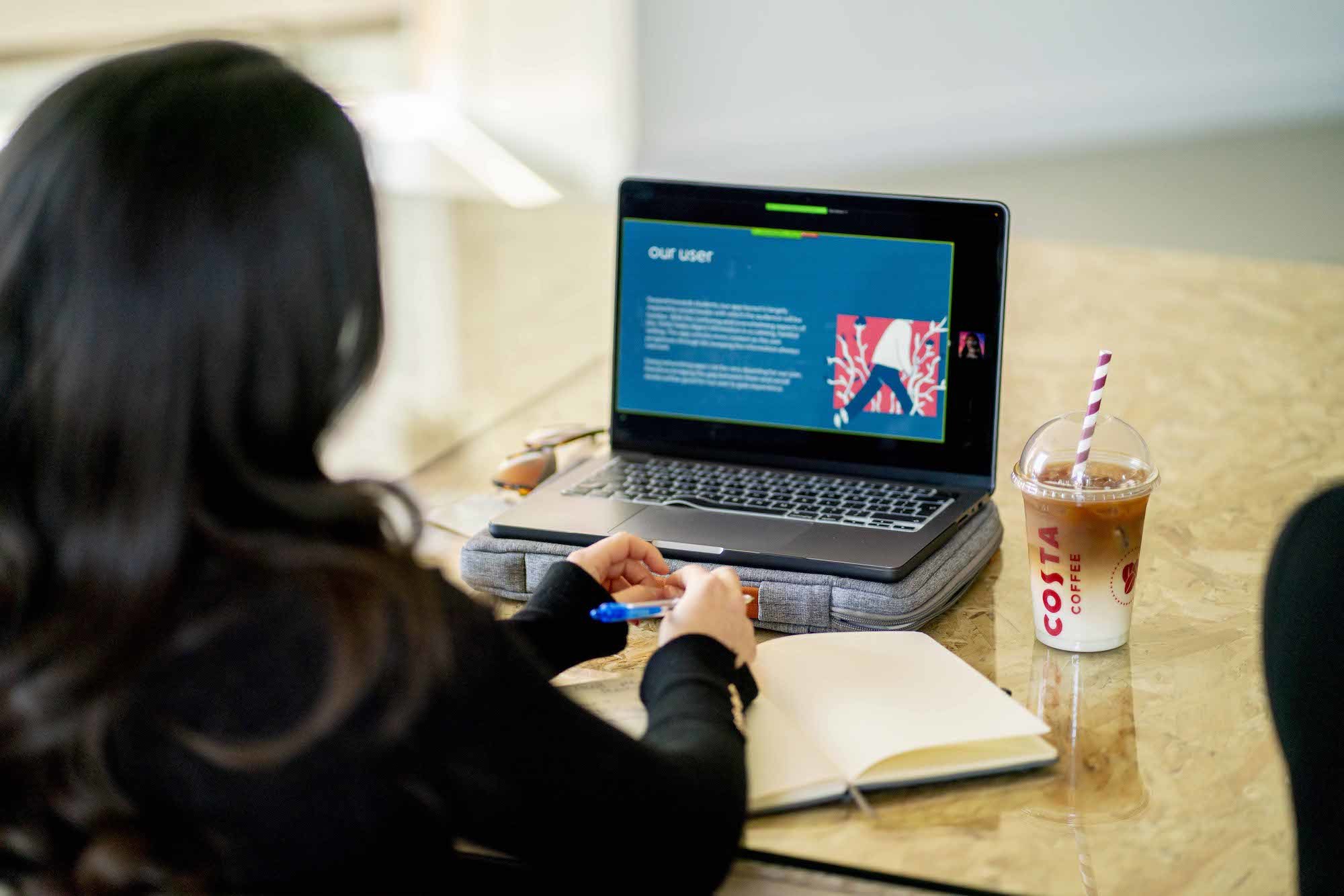 The back of a person's head, with a laptop open to a screen entitled "Our user".