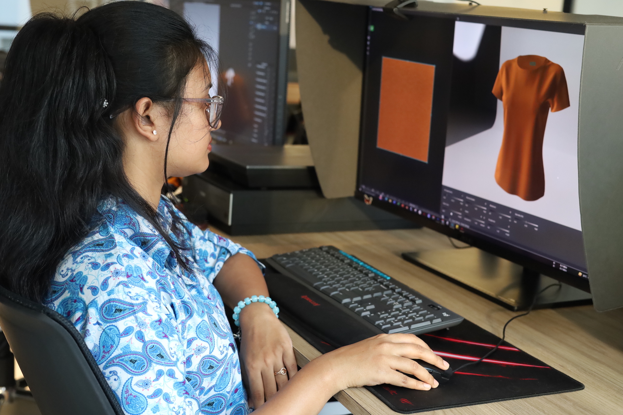 A person using digital fashion software to work on a garment.