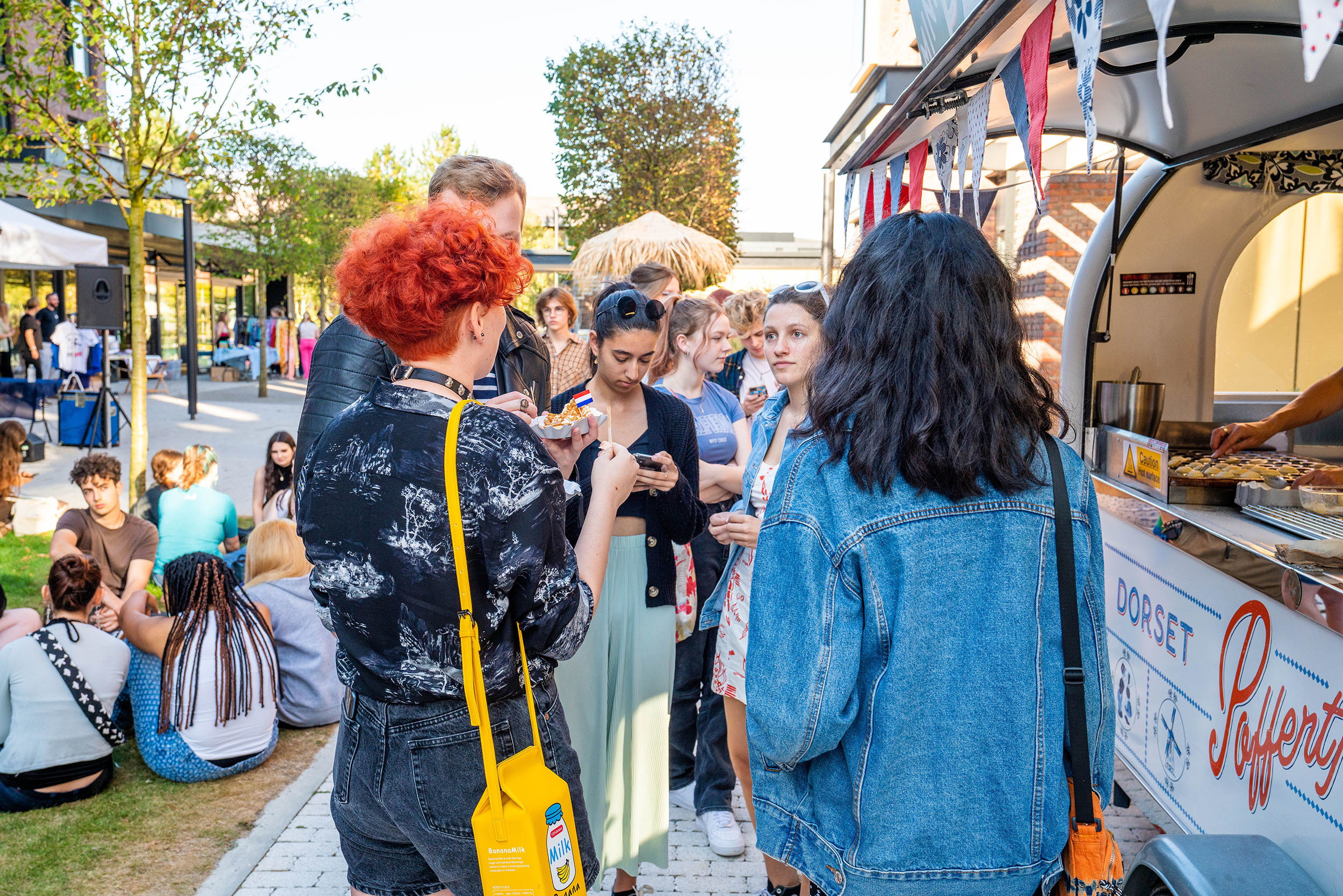 A group of students mingling outside a Dutch pancake van on a university pancake.