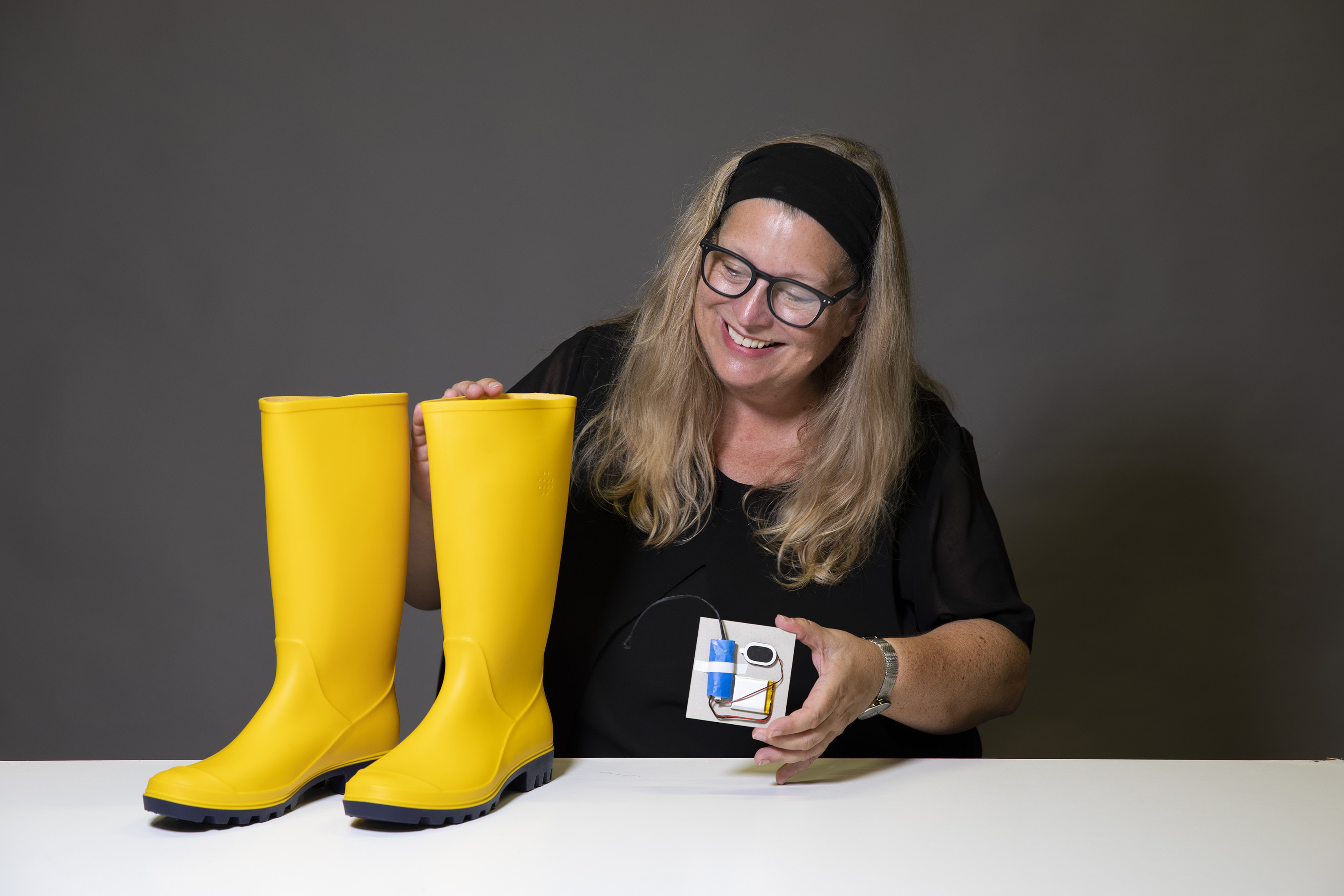 BA (Hons) Graphic Design Senior Lecturer A. Stevens standing next to a pair of yellow Wellington boots.