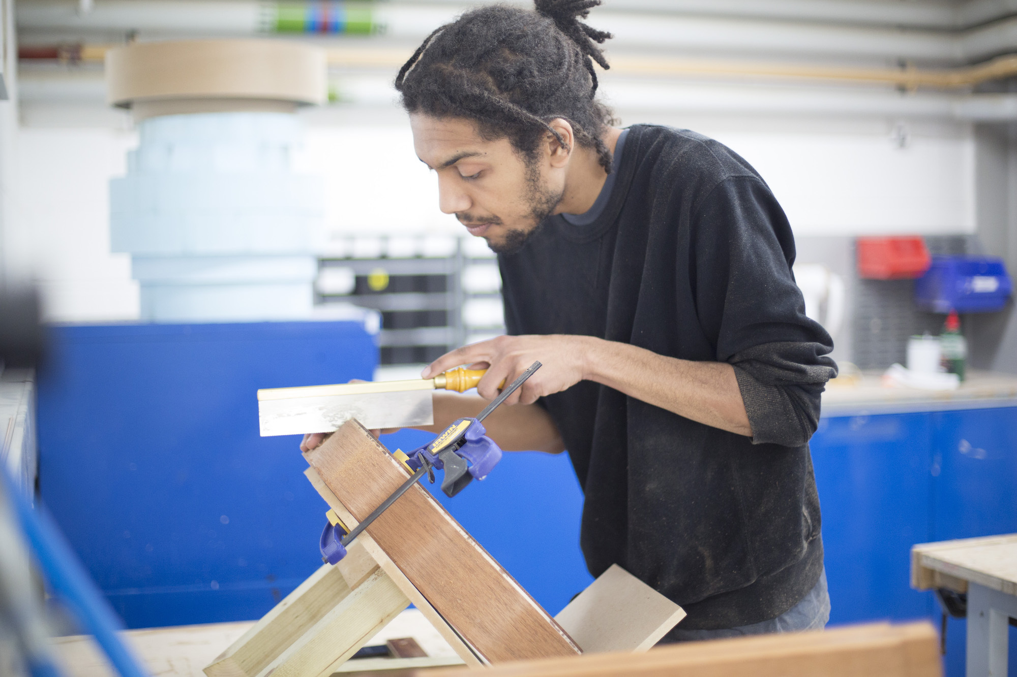 A student working with a small saw in the workshop on AUB campus.