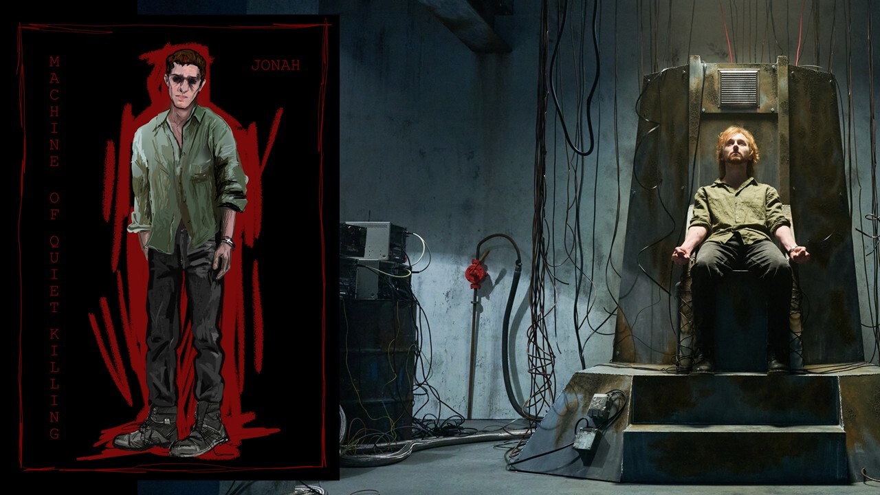Theatre stage with two men: one standing in red-curtained doorway wearing green jumpsuit, another seated in large grey chair with overhead apparatus.
