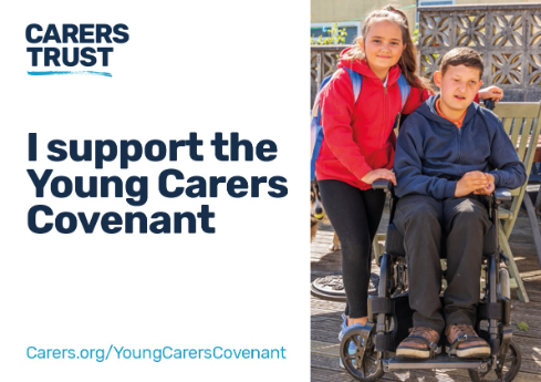 A Carers Trust poster stating “I support the Young Carers Covenant” beside a girl standing behind a boy in a wheelchair outdoors.