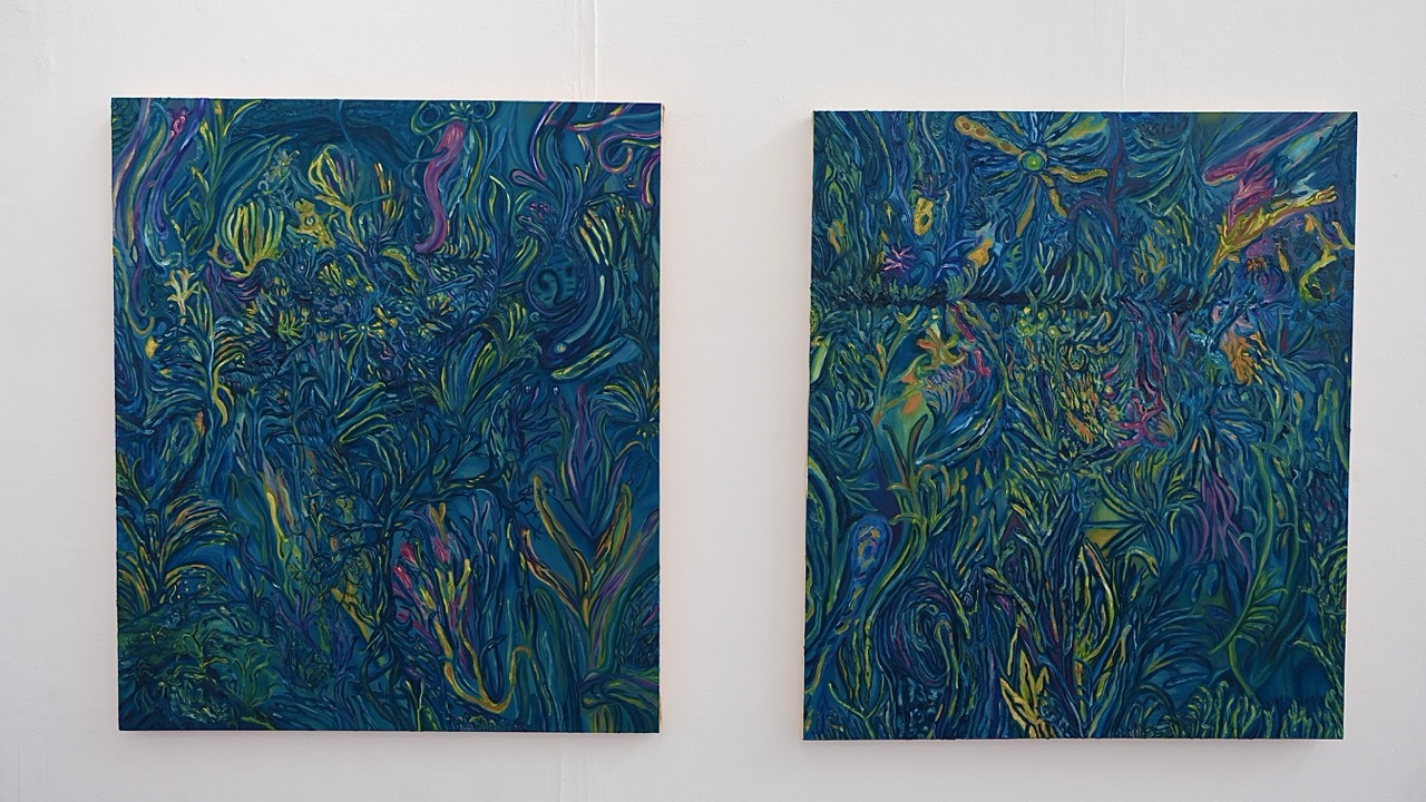Two abstract paintings displayed on a white wall. The left piece features a vibrant swirl of green and blue tones with hints of yellow and pink, while the right piece presents a similar design with a more intricate pattern and additional colours.