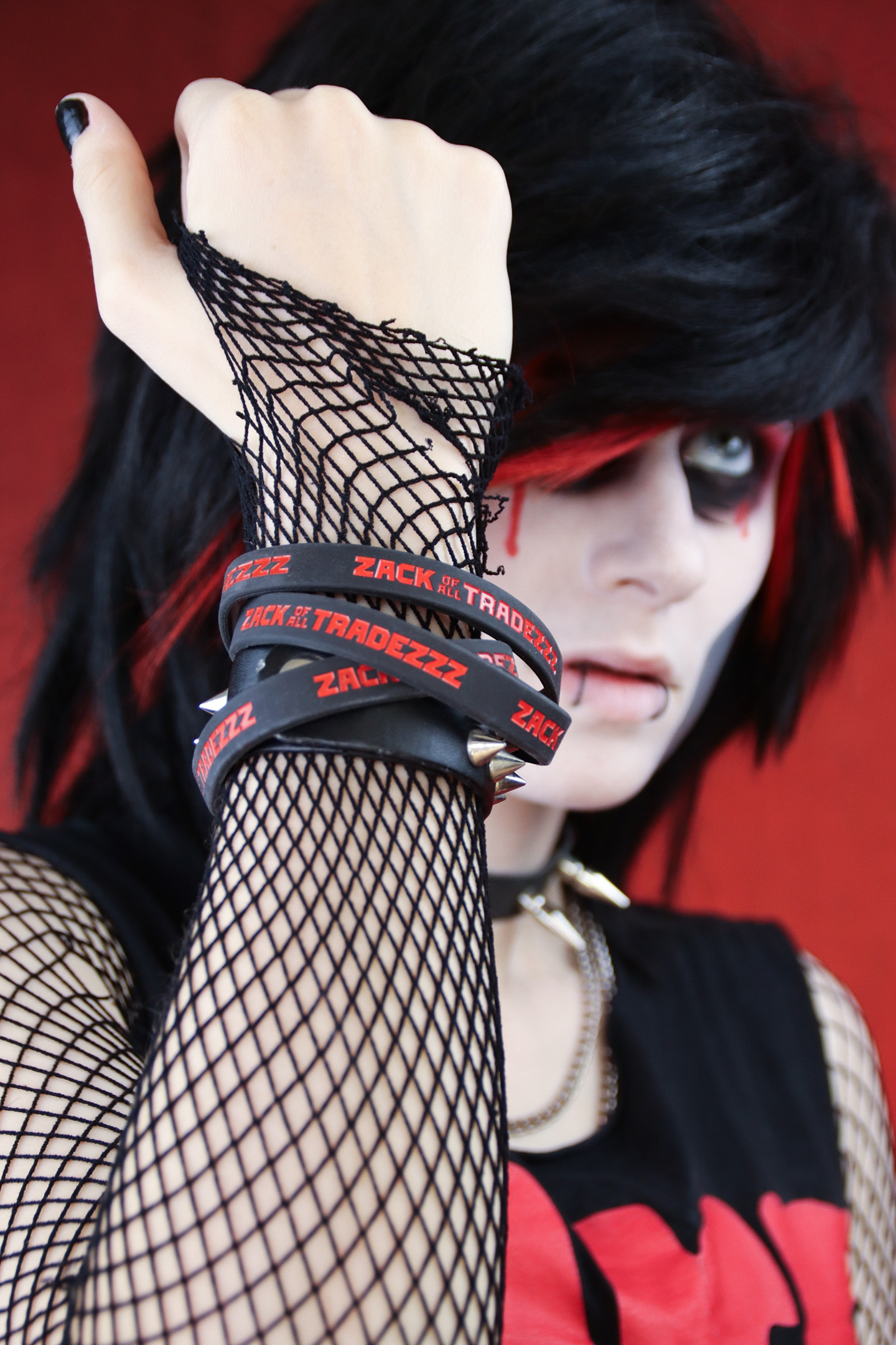 Close-up of A. Gaughan as Zack of all Tradezzz wearing fishnet sleeves and several wristbands.
