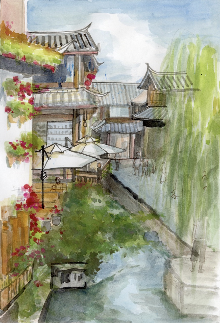 A watercolour illustration of a narrow canal lined with traditional buildings, flowering balconies and white parasols, with a willow tree on the right and reflections in the water.