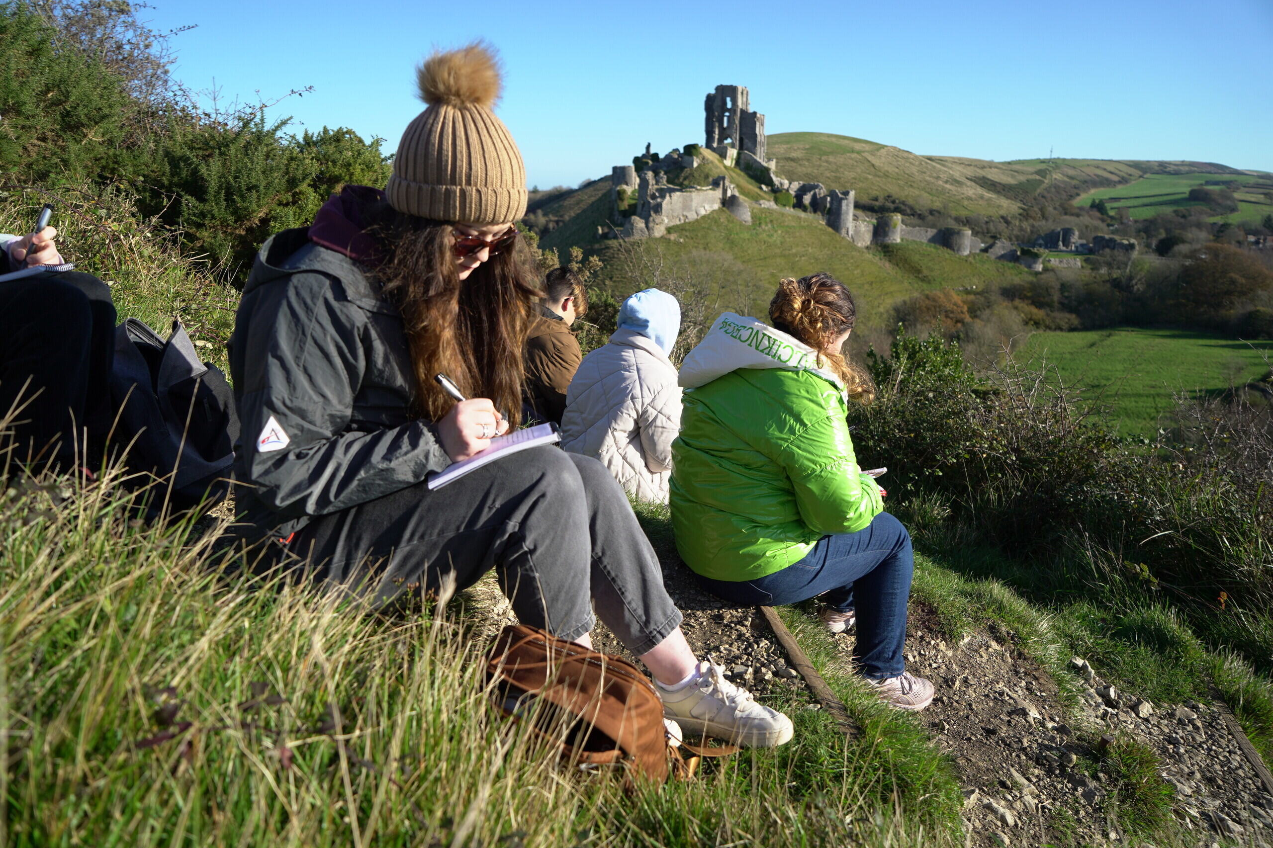 A Creative Writing student writing with Corfe Castle in the background.