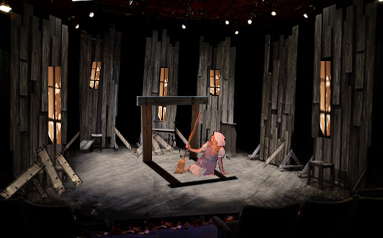 A person in costume holding a broom and lying on the ground surrounded by panels with windows on them.