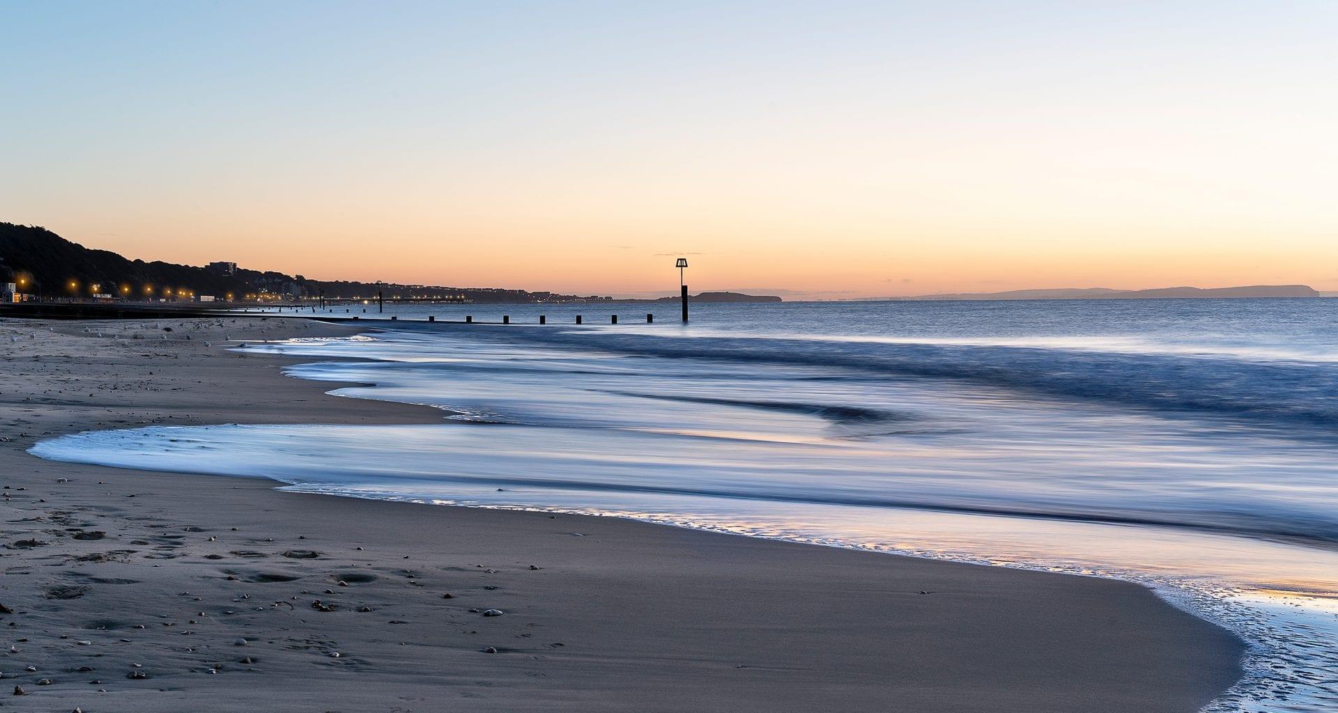 A beach with water lapping the shore from the right-hand side.