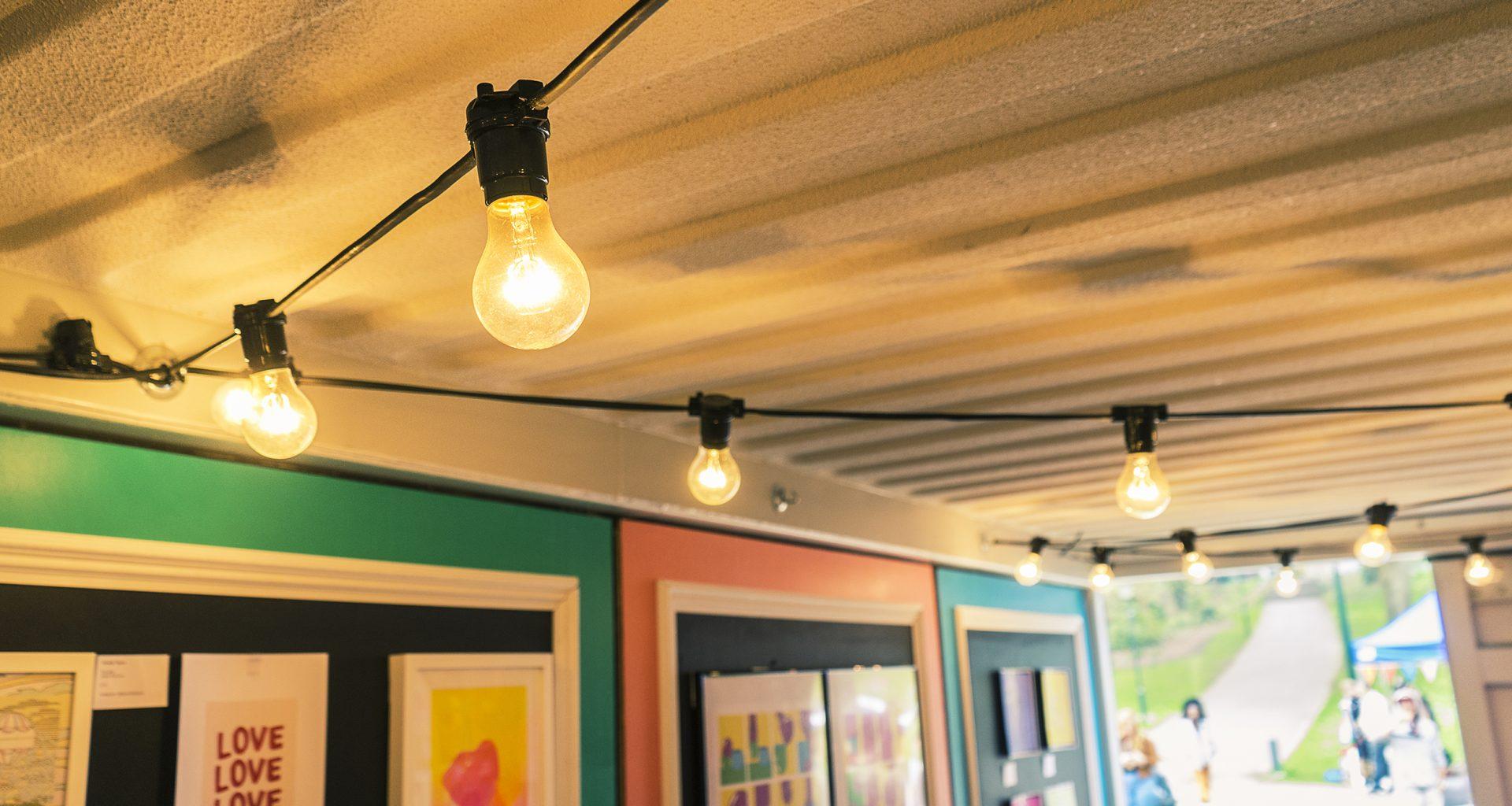 A string of lightbulbs hanging along a ceiling.