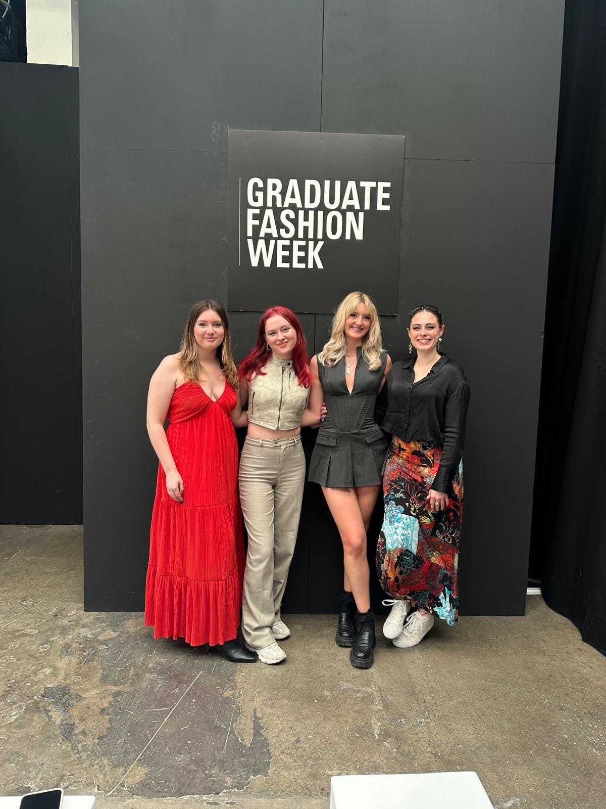 BA (Hons) Fashion students at GFW 2024 stood in front of a black sign.