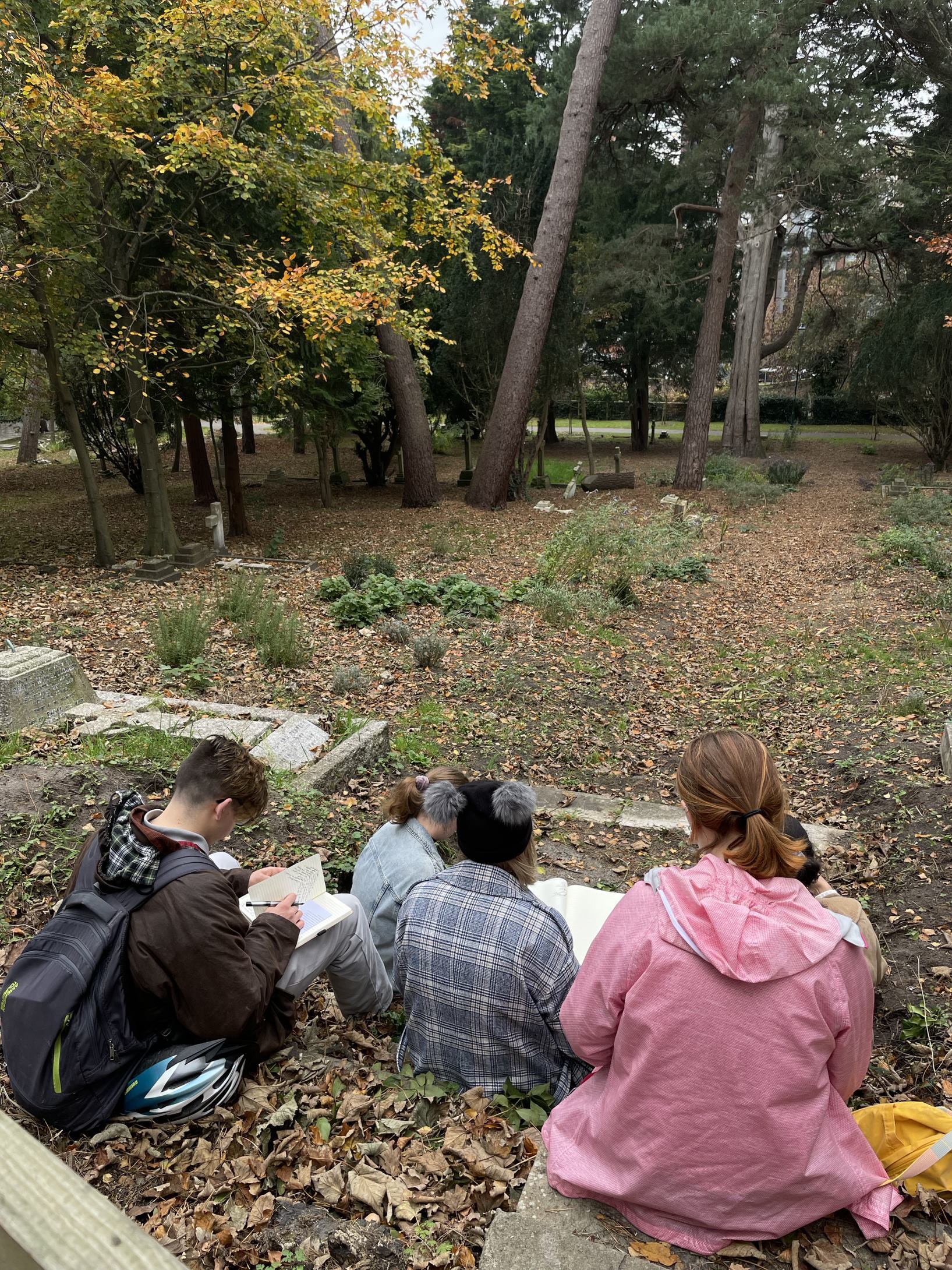 Creative Writing students writing in St Peter's Church graveyard.