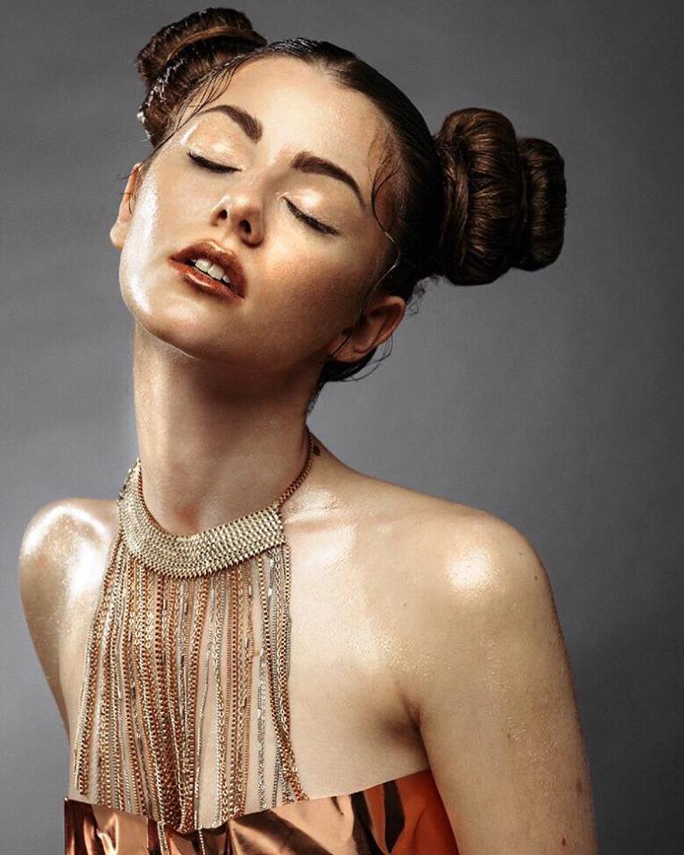 Model with their eyes closed with an Egyptian-style necklace and gold-coloured make-up.