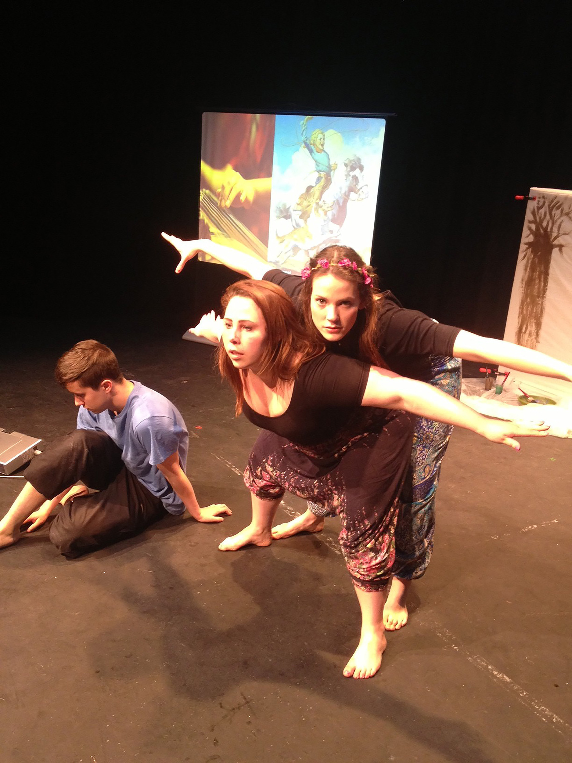 two actors – one standing behind the other with their arms spread