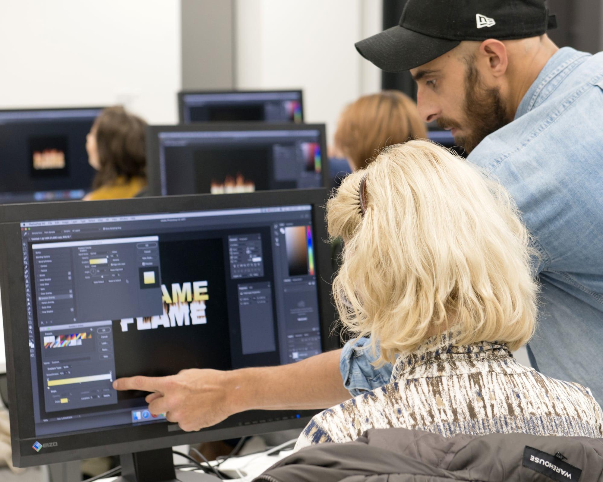 Tutor giving student guidance on a computer