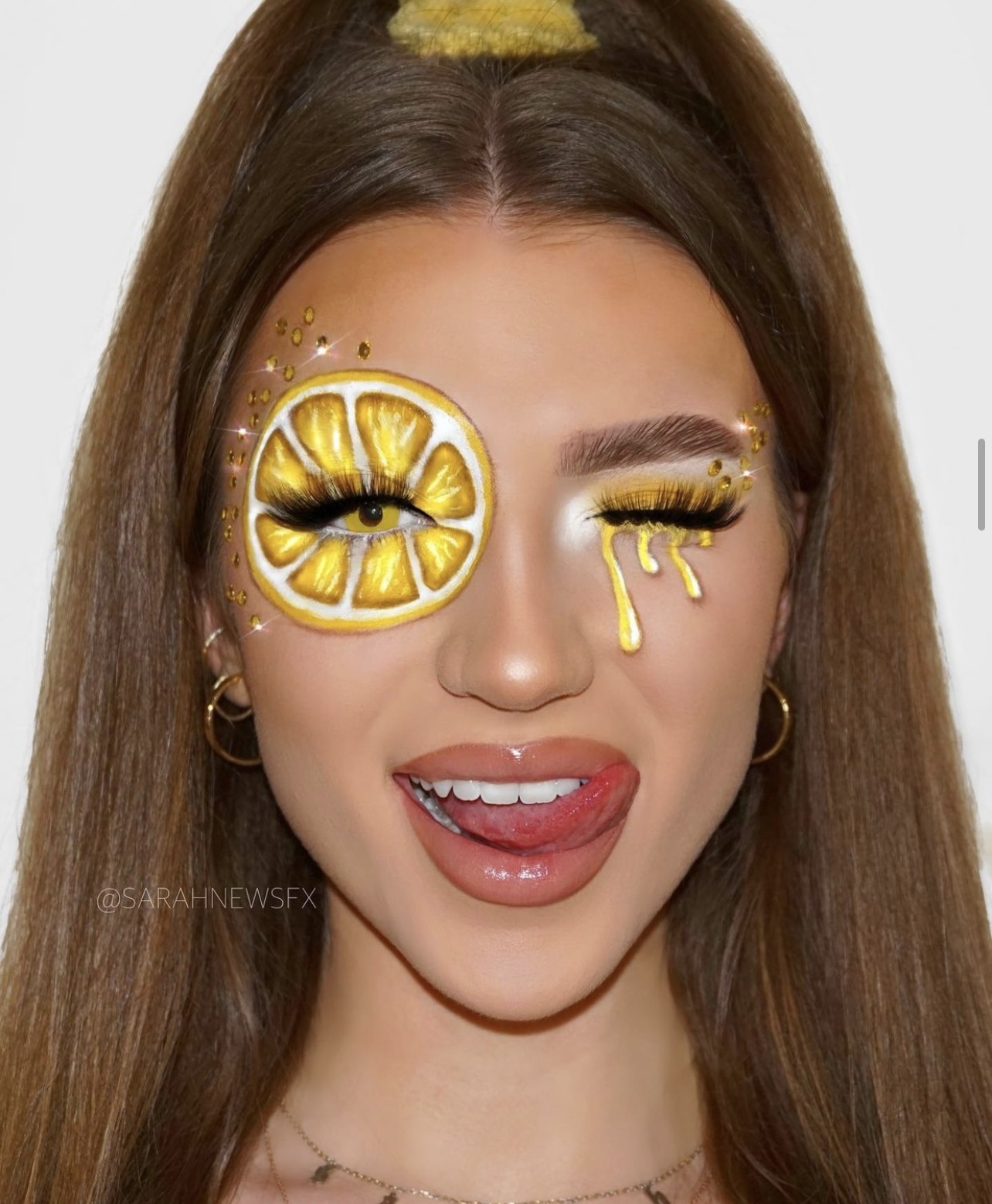 Headshot of a model sticking their tongue out and winking. A lemon has been drawn around their right eye.